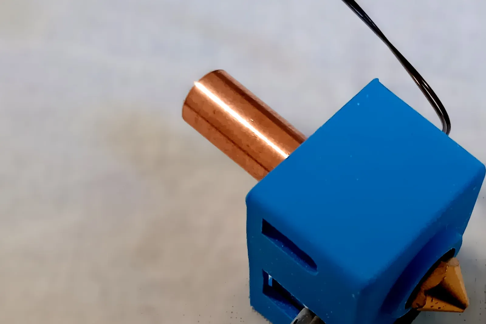A bare hot end: heater block, copper heat break and brass nozzle