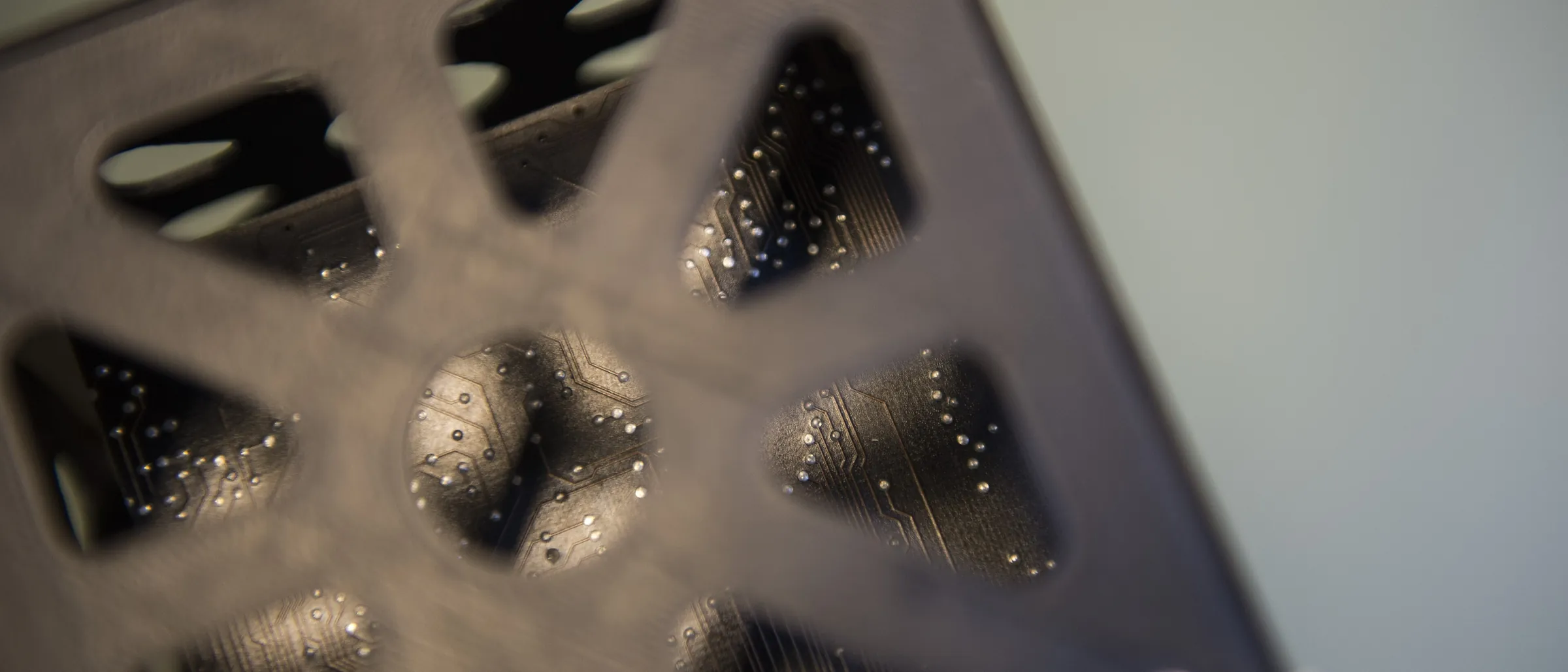 A close view of a PEEK satellite frame printed by ESA, its lattice wall open over circuit traces built into the part