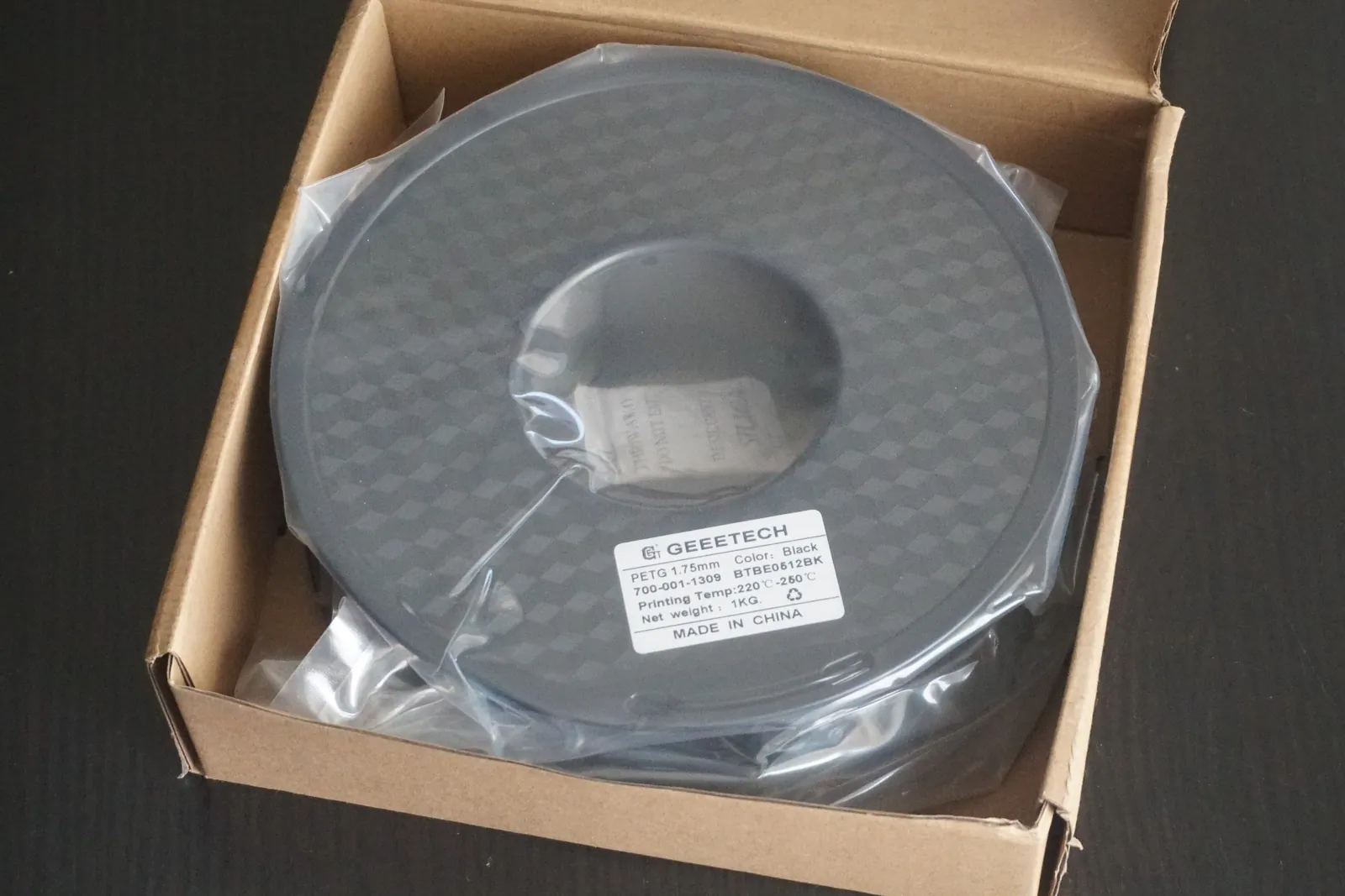 A one kilogram spool of PETG sealed in a bag inside its box