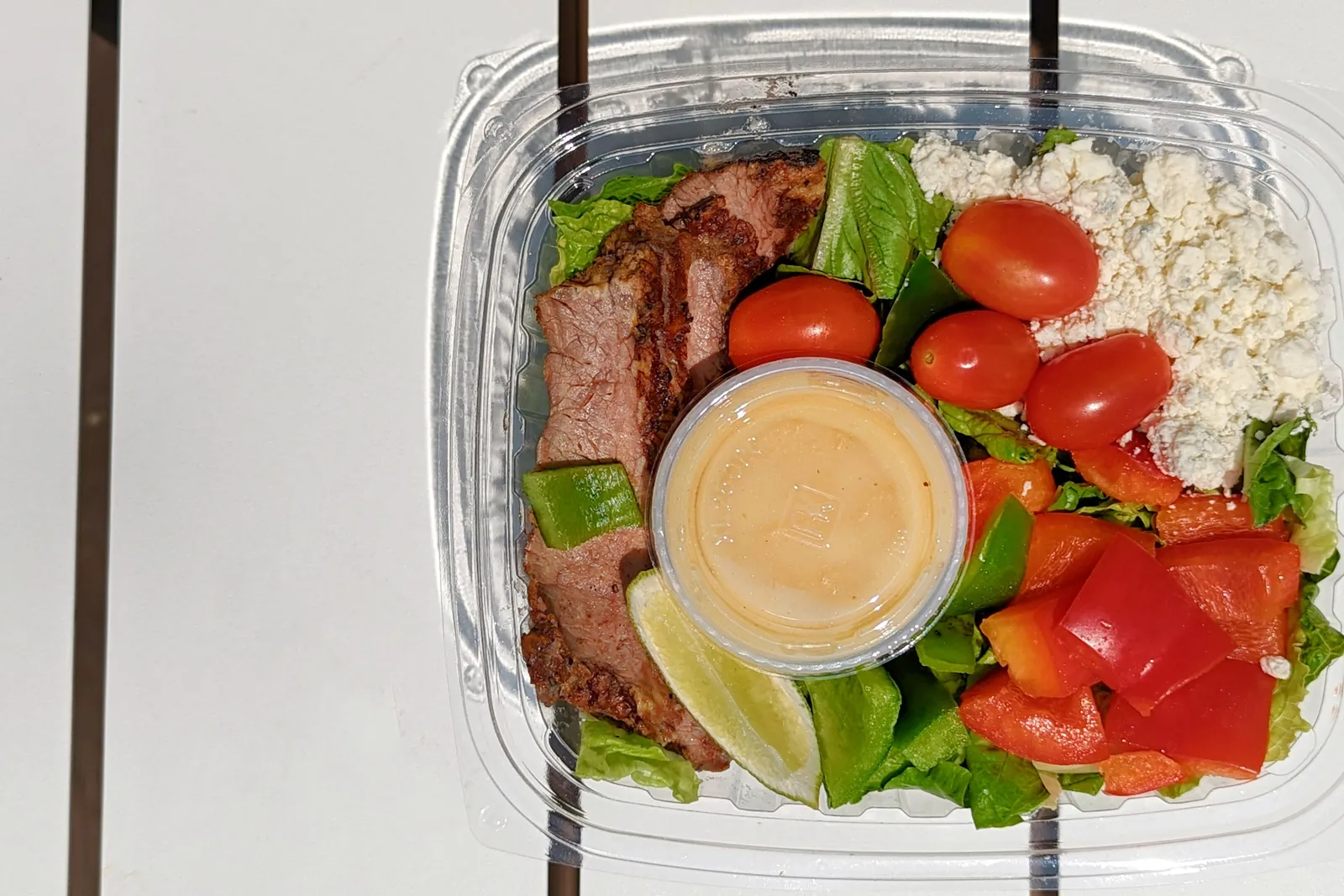 A ready-to-eat salad in a clear plastic clamshell